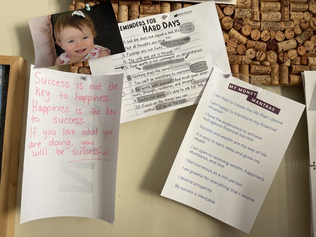 Positive mantras stuck to a pinboard in a home office