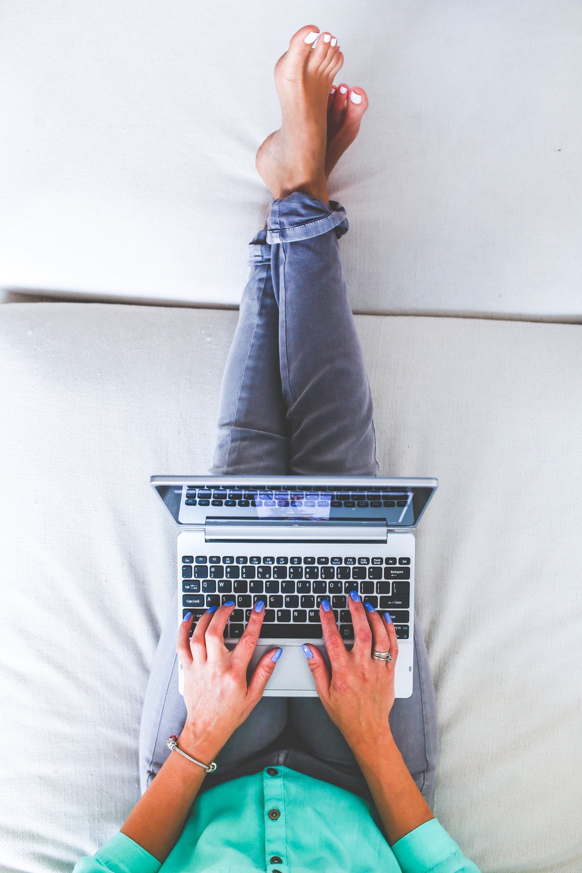 lady typing on bed